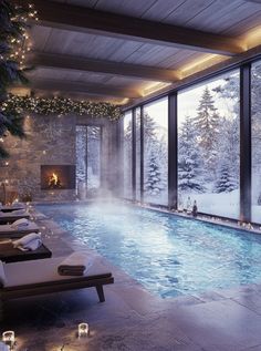 an indoor swimming pool surrounded by snow covered trees