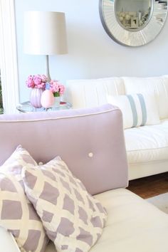 a living room with white couches and pillows