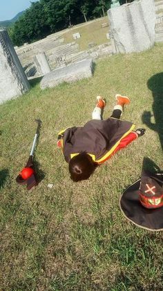 a person laying on the ground with their hat and other items in front of them