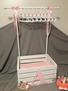 a pink and white baby's changing table with flowers on the floor next to it