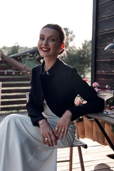 a woman sitting on top of a wooden bench