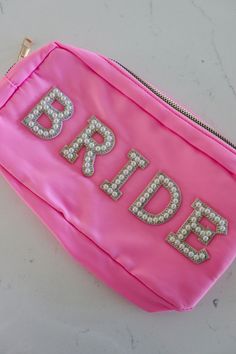 a pink bag with the word bride on it and sequins in the letters