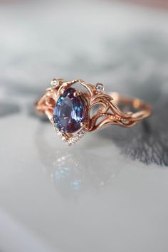 a close up view of a ring with an oval shaped blue stone in the center