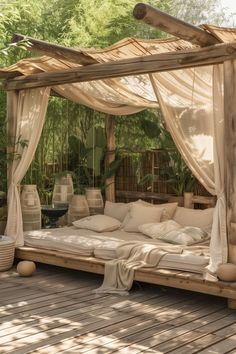 an outdoor bed with curtains and pillows on it