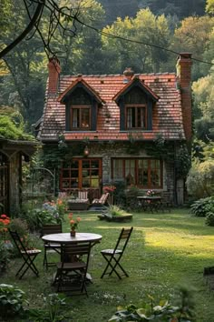 a small house in the middle of a lush green yard with chairs and tables around it