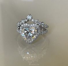 a heart shaped diamond ring with diamonds around it