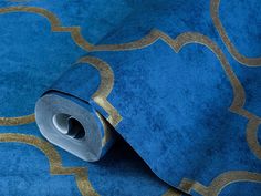 a roll of blue and gold wallpaper with an intricate design on the bottom half