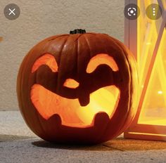 a carved pumpkin sitting next to a window