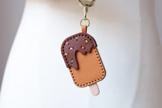 an ice cream keychain with sprinkles is hanging from a mannequin's torso