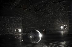 an artistic display in the dark with lights and bubbles floating on water next to each other