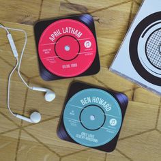 three records and headphones sitting on top of a wooden table next to each other