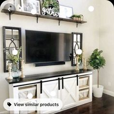 a flat screen tv mounted to the side of a white entertainment center in a living room