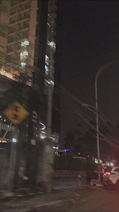 a blurry photo of cars driving down the street in front of tall buildings at night