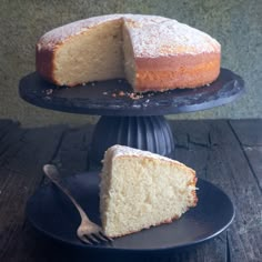 a piece of cake on a plate with a fork next to it and another slice missing from the cake