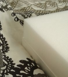 the corner of a bed with black and white bedspread