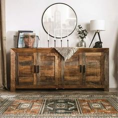 a wooden sideboard sitting on top of a rug in a living room next to a window