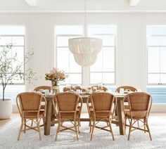 a dining room table with chairs and a chandelier hanging from it's ceiling