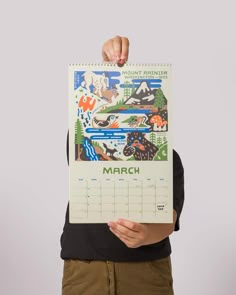 a person holding up a calendar in front of their face with the word march on it