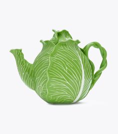 a green ceramic teapot with leafy designs on the front and sides, set against a white background