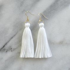 By popular demand, finally...white tassel earrings from Libby & Smee! These handmade tassel earrings will make a big style impact, whether you’re wearing them with jeans and a t-shirt or with a dress. At less than one-tenth of an ounce, Libby & Smee statement earrings feel virtually weightless!+ super lightweight cotton tassel in white+ gold-plated stainless steel ear wire hooks (lead-free and nickel-free)+ comes with plastic earring back for security+ LONG is 3.25 inches and MINI is 2.5 Elegant White Tassel Earrings For Pierced Ears, White Fringe Tassel Earrings As Gift, White Tassel Earrings With Latkans As Gift, Bohemian White Tassel Earrings For Pierced Ears, White Tassel Earrings With Latkans For Gift, White Tassel Dangle Earrings, White Dangle Tassel Earrings With Latkans, White Dangle Tassel Earrings As Gift, White Tassel Earrings Gift