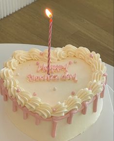 a heart shaped birthday cake with a lit candle