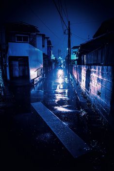 a dark alley with rain falling on the ground