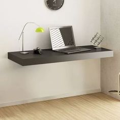 a laptop computer sitting on top of a desk next to a heater and clock