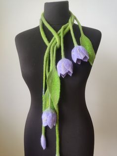 a mannequin wearing a green scarf with purple flowers on it