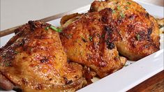 two pieces of chicken sitting on top of a white plate