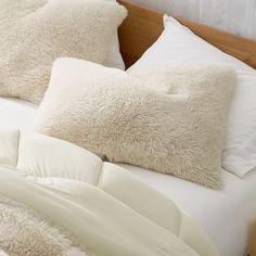 a bed with white pillows and blankets on it