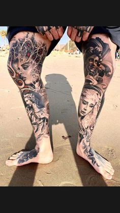 a man with tattoos on his legs and feet standing in the sand at the beach