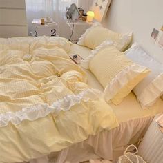 a bed with yellow sheets and white pillows