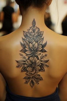 A large floral tattoo on a woman's back, featuring detailed flowers and leaves. Back Tattoos For Women Spine, Intricate Back Tattoo, Elegant Back Tattoos For Women, Tattoos For Women Spine, Elegant Back Tattoos, Back Tattoo Placements, Back Tattoos For Women