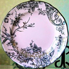 the plate is decorated with black and white flowers