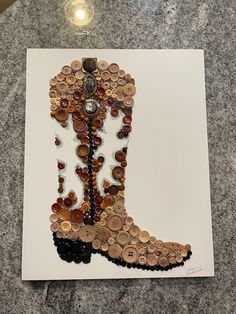 an art piece made out of buttons and other items on top of a white paper