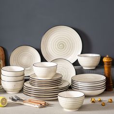 a table topped with lots of white plates and bowls