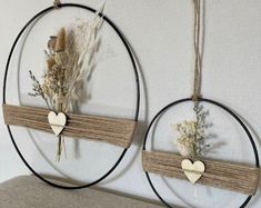 two circular wall hangings with flowers and hearts on them, one is made out of wood