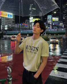 a man standing in the rain holding an umbrella