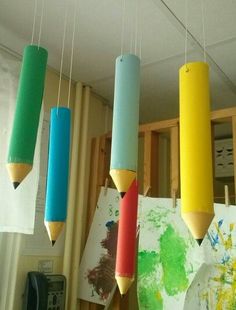 several colored pencils are hanging from the ceiling