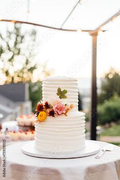 a white wedding cake sitting on top of a table