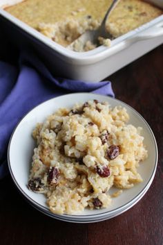 a white plate topped with rice and raisins next to a casserole dish