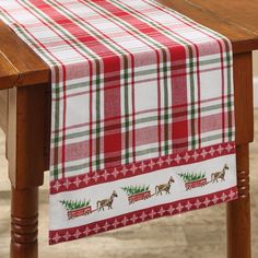 a christmas table runner with reindeers and trees on red, white and green plaid