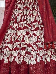 The red color tussar silk lehenga with floral and foil print work is a captivating ensemble that embodies both tradition and modernity. This semi-stitched lehenga, designed to fit up to 42 inches, boasts a luxurious 3.80-meter flair, providing a dramatic and elegant silhouette. The 42-inch length ensures the lehenga drapes beautifully, creating a striking visual impact. Accompanied by an unstitched choli with 0.80-meter material, this outfit allows for a tailored fit, enhancing both comfort and Navratri Silk Floor-length Sets, Floor-length Silk Sets For Navratri, Silk Floor-length Sets For Diwali, Floor-length Silk Sets For Diwali, Red Semi-stitched Sets With Zari Work, Unstitched Red Sharara With Dupatta, Silk Lehenga With Printed Motifs And Traditional Drape, Silk Lehenga With Printed Motifs In Traditional Drape, Unstitched Art Silk Lehenga With Printed Motifs