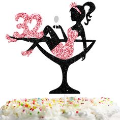 a cake with a silhouette of a woman sitting on a cocktail glass holding the number thirty three