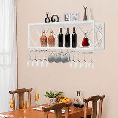 a dining room table with wine glasses hanging on the wall