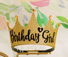 a birthday girl crown on top of a stand with the words,'birthday girl'in black and gold