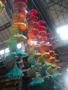 many colorful umbrellas are hanging from the ceiling