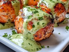 some chicken wrapped in sauce and garnished with parsley on a white plate