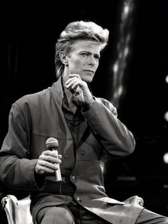 an old black and white photo of a man holding a microphone in his right hand