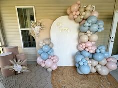 balloons are arranged in the shape of an arch for a baby's first birthday